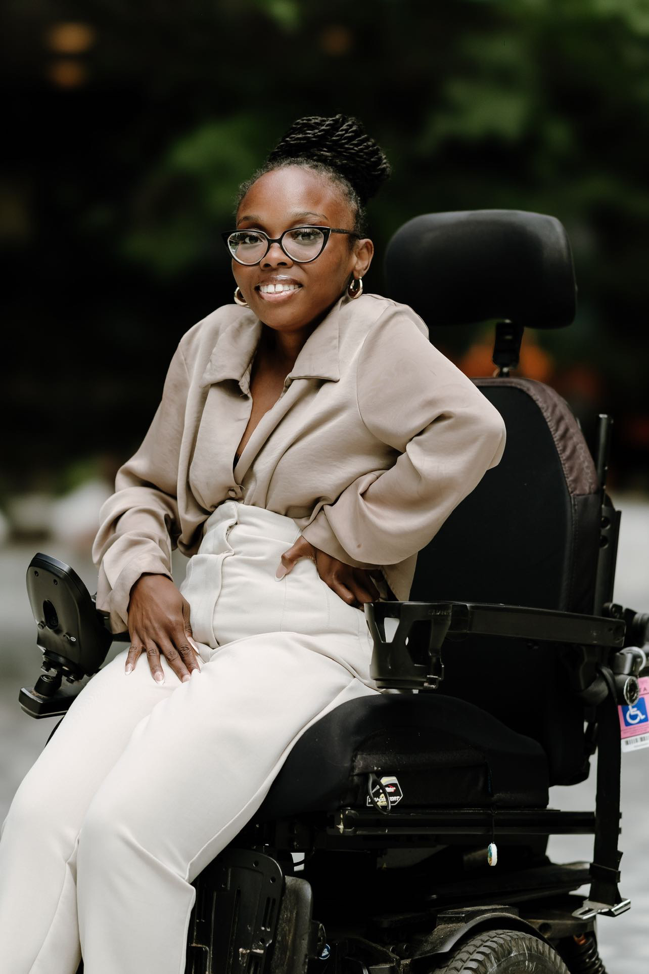 Professional Profile Shot of Nila Morton wearing a tan outfit sitting in her Power Wheelchair